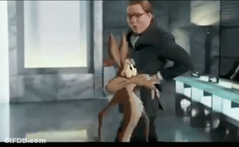 A Man In A Suit Is Holding A Cartoon Rabbit In His Arms In A Room . GIF