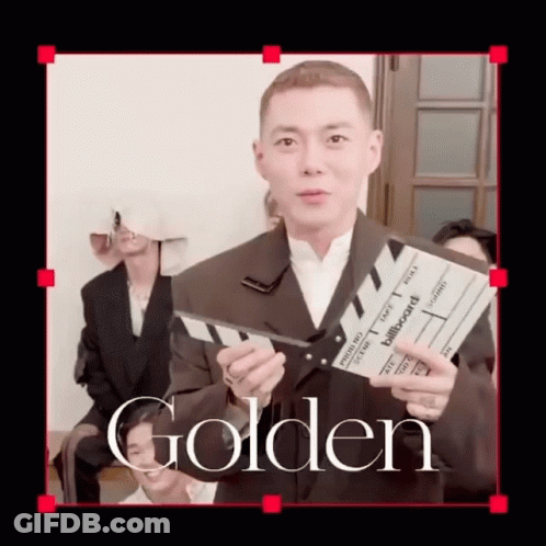 A Man In A Suit Is Holding A Clapper Board That Says Billboard On It GIF