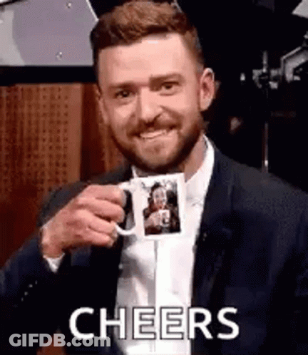 A Man In A Suit Is Holding A Coffee Mug With A Picture Of A Woman On It . GIF