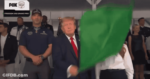 A Man In A Suit Is Holding A Green Flag In Front Of A Fox Advertisement GIF