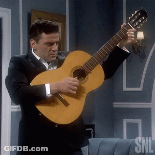 A Man In A Suit Is Holding A Guitar With The Snl Logo In The Corner GIF