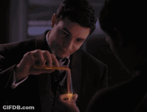 A Man In A Suit Is Holding A Lit Lighter GIF