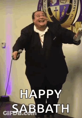 A Man In A Suit Is Holding A Microphone With The Words Happy Sabbath Below Him GIF