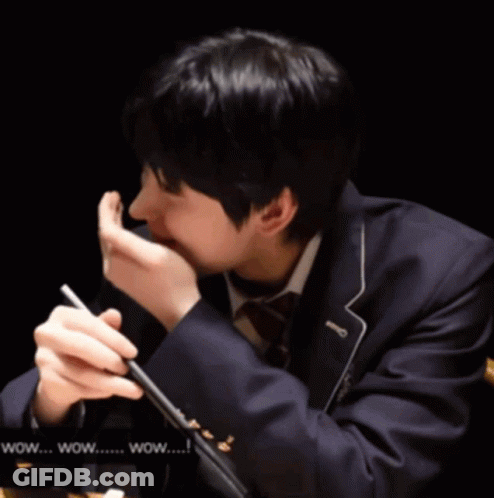 A Man In A Suit Is Holding A Pen In His Hand And Says Wow GIF