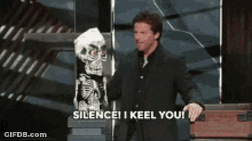 A Man In A Suit Is Holding A Puppet Of A Skeleton And Says Silence I Keel You GIF