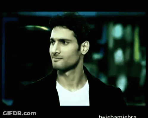 A Man In A Suit Is Holding A Red Umbrella In A Blurry Photo With The Words Twishamishra At The Bottom GIF