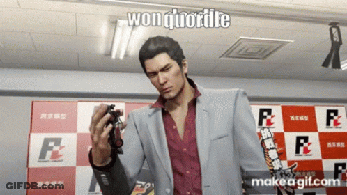 A Man In A Suit Is Holding A Toy In Front Of A Checkered Wall That Says F2 GIF