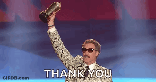 A Man In A Suit Is Holding A Trophy In His Hand And Saying Thank You . GIF