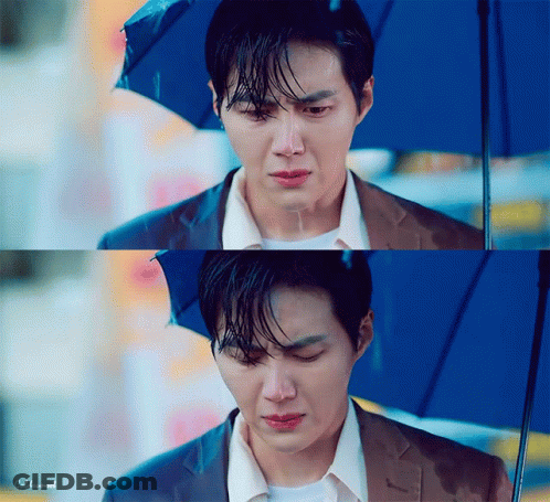A Man In A Suit Is Holding An Umbrella And Crying In The Rain . GIF