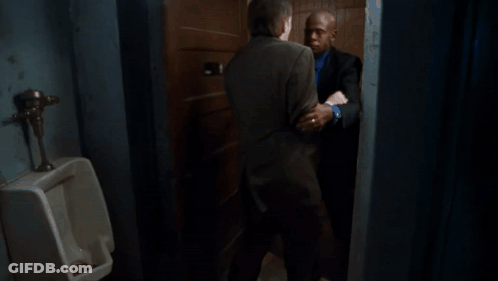 A Man In A Suit Is Holding Another Man 'S Neck GIF