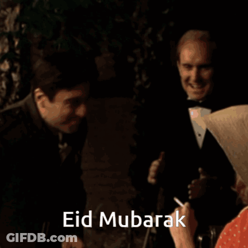 A Man In A Suit Is Hugging Another Man With The Words Eid Mubarak Written On The Bottom GIF