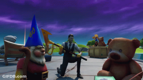A Man In A Suit Is Kneeling Down Next To A Teddy Bear And A Gnome GIF