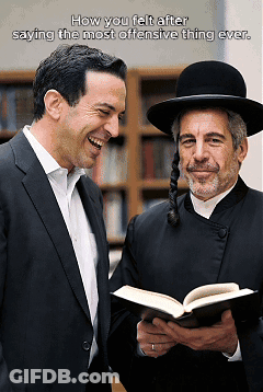 A Man In A Suit Is Laughing Next To A Man In A Hat Who Is Holding A Book GIF