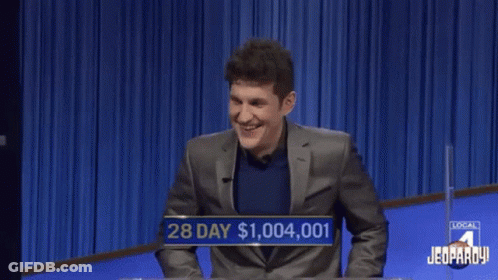 A Man In A Suit Is Laughing While Playing A Game Of Jeopardy GIF