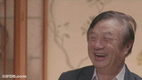 A Man In A Suit Is Laughing With His Eyes Closed . GIF