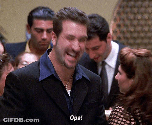 A Man In A Suit Is Laughing With The Word Opa Written On His Face GIF