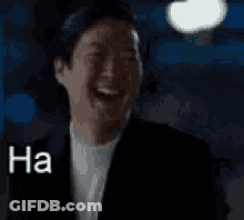 A Man In A Suit Is Laughing With The Words `` Ha Haaa '' Written Next To Him . GIF