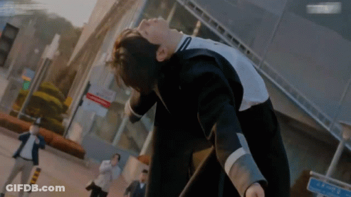 A Man In A Suit Is Laying On His Back In Front Of A Sign That Says ' A ' On It GIF