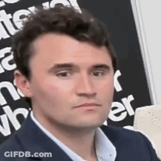 A Man In A Suit Is Making A Funny Face In Front Of A Blackboard . GIF