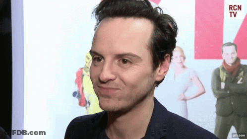 A Man In A Suit Is Making A Funny Face In Front Of A Rcn Tv Sign GIF