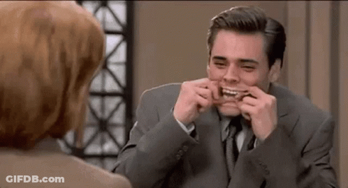 A Man In A Suit Is Making A Funny Face While Talking To A Woman . GIF