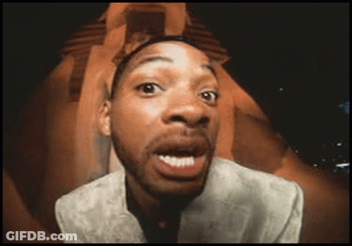 A Man In A Suit Is Making A Funny Face With His Mouth Open GIF