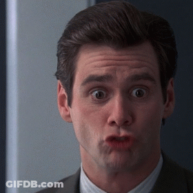 A Man In A Suit Is Making A Funny Face With His Mouth Open GIF