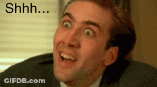 A Man In A Suit Is Making A Funny Face With His Mouth Open . GIF