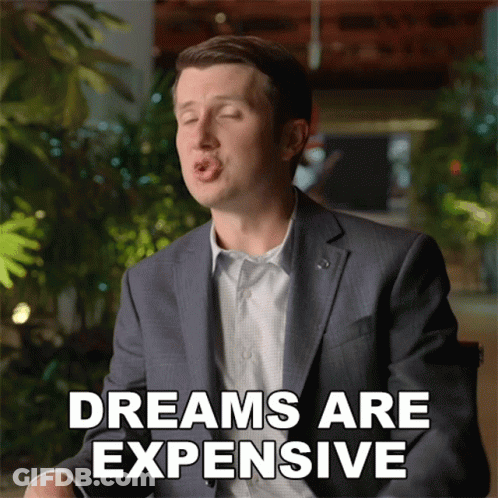 A Man In A Suit Is Making A Funny Face With The Words Dreams Are Expensive Behind Him GIF
