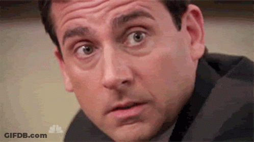 A Man In A Suit Is Making A Surprised Face . GIF
