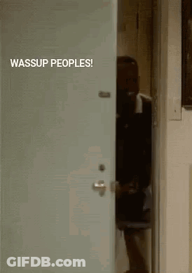 A Man In A Suit Is Peeking Out Of A Door With The Words Wassup Peoples Written On It . GIF