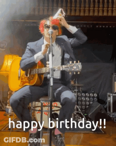 A Man In A Suit Is Playing A Guitar And Singing Into A Microphone With The Words Happy Birthday Written Below Him GIF