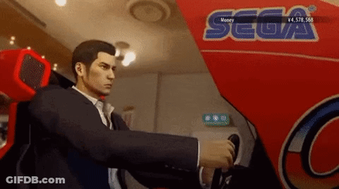 A Man In A Suit Is Playing A Video Game In Front Of A Sign That Says Sega GIF