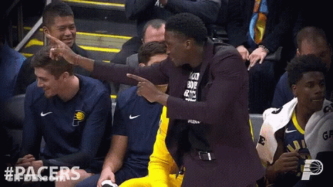 A Man In A Suit Is Pointing At Another Man In A Black Shirt That Says " I Love You " GIF