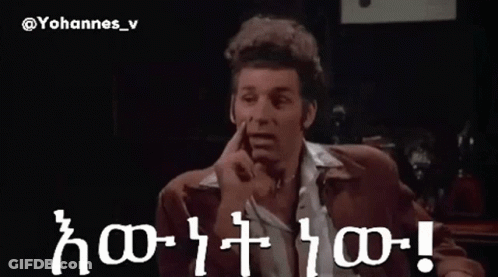A Man In A Suit Is Pointing At Something In A Dark Room With The Words Yohannes_v Written On The Bottom GIF