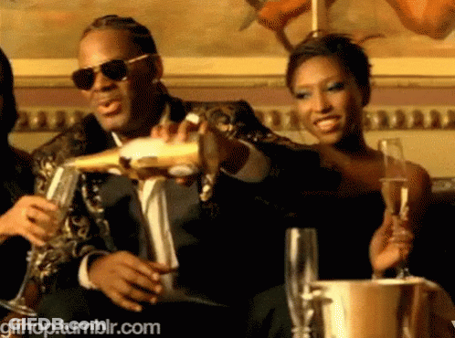 A Man In A Suit Is Pouring Champagne Into A Glass GIF