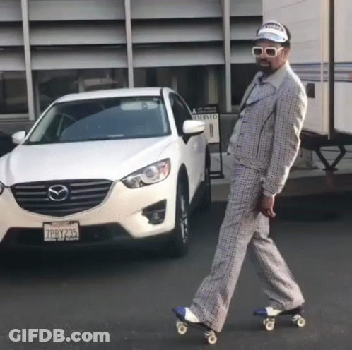 A Man In A Suit Is Rollerblading In Front Of A Mazda GIF