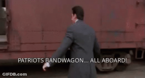 A Man In A Suit Is Running Towards A Train With The Words Patriots Bandwagon All Aboard Written On The Bottom GIF