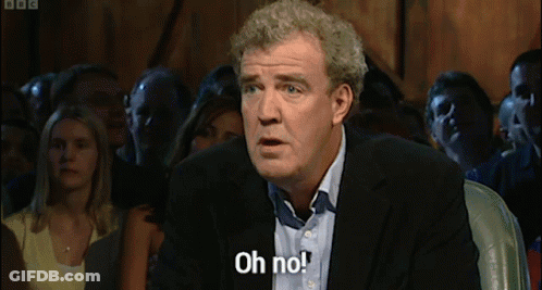 A Man In A Suit Is Saying Oh No In Front Of A Crowd GIF
