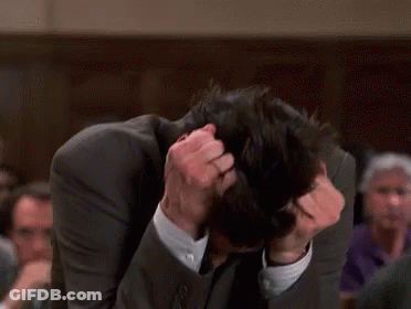 A Man In A Suit Is Scratching His Head GIF