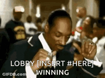 A Man In A Suit Is Singing Into A Microphone With The Words Lobby Insert # Here Winning Behind Him GIF