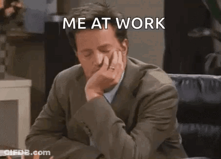 A Man In A Suit Is Sitting At A Desk With His Hand On His Chin And Says `` Me At Work '' . GIF