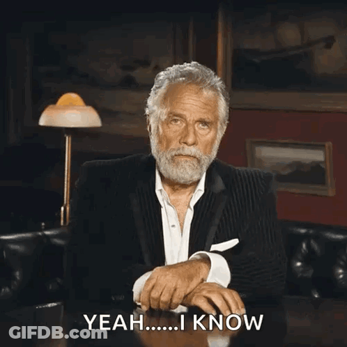 A Man In A Suit Is Sitting At A Table And Says " Yeah I Know " GIF