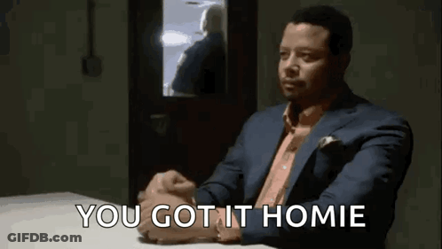 A Man In A Suit Is Sitting At A Table With His Hands Folded And The Words `` You Got It Homie '' . GIF