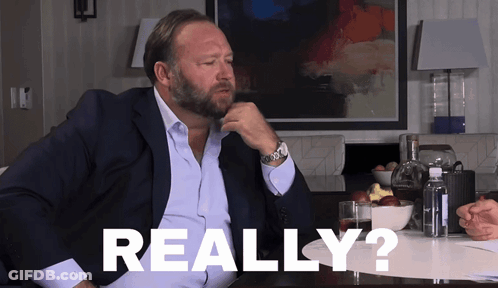 A Man In A Suit Is Sitting At A Table With The Word Really Written On The Table GIF