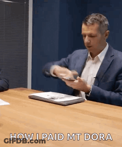 A Man In A Suit Is Sitting At A Table With The Words How I Paid Mt Dora GIF