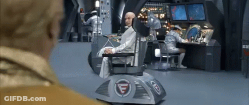 A Man In A Suit Is Sitting In A Chair In A Room . GIF