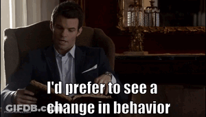 A Man In A Suit Is Sitting In A Chair Reading A Book And Says I 'D Prefer To See A Change GIF
