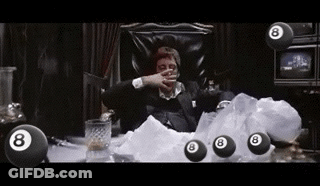 A Man In A Suit Is Sitting In A Chair Surrounded By Pool Balls . GIF