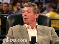 A Man In A Suit Is Sitting In A Chair With A Microphone In Front Of Him GIF